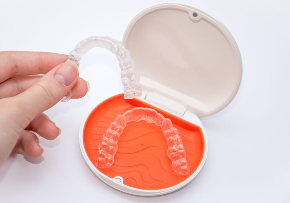 Transparent aligners retainers in a storage case. Invisible braces. Clear teeth straighteners. Plastic bracers